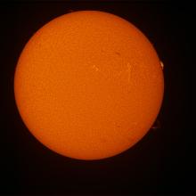 Disk view of the Sun with a prominence of plasma on the right side of the disk.