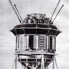 A spacecraft with a cylinder base shape and multiple antennae and other objects attached.