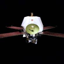 A spacecraft with an oblong-shaped base with one satellite and four solar panels attached to the sides of the base.