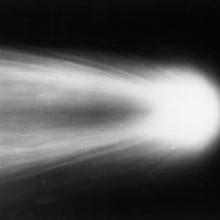 Close-up view of Halley's Comet as it leaves a meteor trail in the sky behind it.