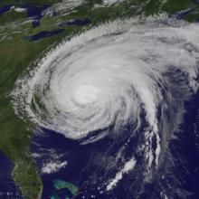 Satellite view of Hurricane Irene, a large tropical cyclone in the Atlantic basin, as seen after landfall in North Carolina. The hurricane's outer bands stretch towards the New England region.