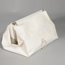 White cloth stowage bag used during Apollo 11 mission. Bag has one zipper entry at the top of the bag.