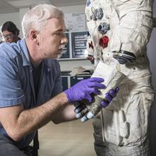 Exhibits Specialist Adam Bradshaw with the white beta cloth lunar spacesuit 