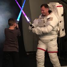 Nick Hague, class of 2013 astronaut, tweeted this photo of himself being “ambushed” by his son during an official NASA photo shoot