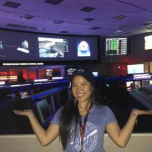 Programmer Melody Ho standing inside mission control at the NASA Jet Propulsion Lab