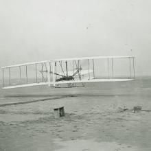 Black and white historic photo of Wright Brothers' first flight