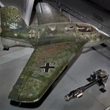 Side view of a green camouflaged German World War II aircraft on display in the Museum.