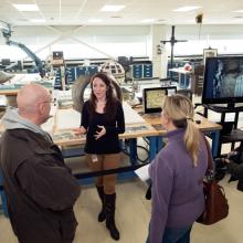 A Museum conservation specialist speaks to three visitors as part of a tour of the Museum's conservation laboratory.