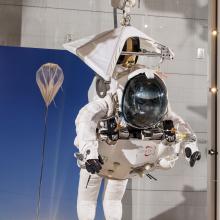 Front view of Alan Eustace's white freefall jumpsuit hanging on display in the Museum