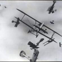 Black and white photo of airplane in the sky. 