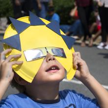 A young visitor at the Udvar-Hazy Center observes the solar eclipse of August 21, 2017 with safe eclipse glasses.