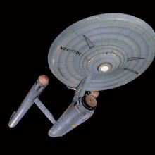 A studio model of the Starship Enterprise, a ship used in the Star Trek franchise with a saucer, two warp drives, and a cargo bay