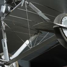 Closeup view of two wheels and metal wheel frame from a Voisin Type 8 aircraft, seen from below