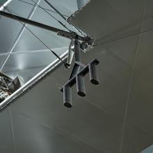 Black metal three-pronged apparatus hanging from metal Voisin Type 8 aircraft