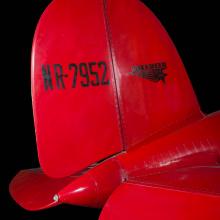 Tail of red Amelia Earhart Lockheed Vega 5B aircraft with "NR-7952" and lockheed logo in black