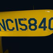 Aircraft registration mark in blue on yellow Staggerwing wing, "NC15840"