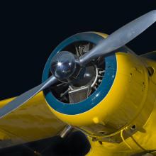 Closeup view of the two-blade propeller and engine from yellow Beechcraft C17L Staggerwing aircraft