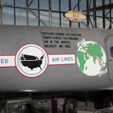 United States Airlines logo, globe, and record details on side of gray Boeing 247-D aircraft in museum