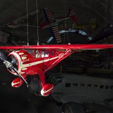 Red monoplane with clipped wings, white trim, and "Little Butch" inscription