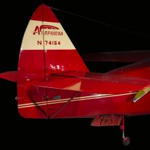 Red and tan painted vertical and horizontal stabilizer of the plane. Painted on the tan parts of the paint are Airphibian and N74154.