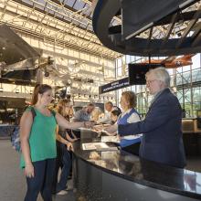 Visitors being helped by the Welcome Center in the Boeing Milestones of Flight Hall