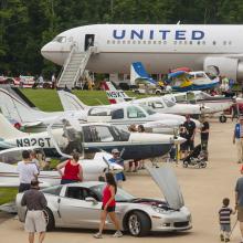 View of the runway at a airplane and car show. 