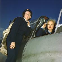 WASP Ann McClellan adjusts her earphones in the cockpit of a BT-13