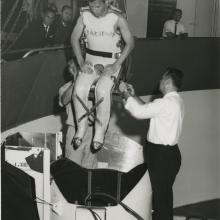 Man in full body restraint being lowered into a centrifuge. 