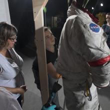 Gene Cernan's Apollo 17 spacesuit being moved out of the exhibit case in the "Apollo to Moon" gallery