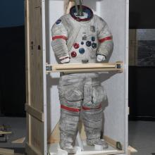 Gene Cernan's Apollo 17 spacesuit being moved out of the exhibit case in the "Apollo to Moon" gallery 