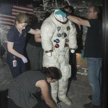 Buzz Aldrin's Apollo 11 spacesuit being moved out of the exhibit case in the "Apollo to Moon" gallery 