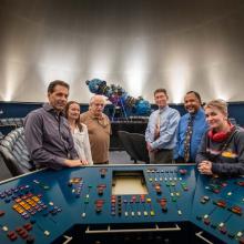 Group of people with Zeiss projector in the background