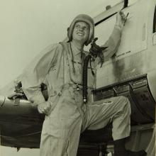 Man in flight suit standing on aircraft