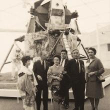 Black and white photo of dignitaries posing in front of the Lunar Module. 