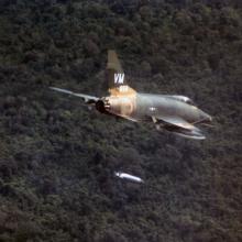 A F-100D aircraft of the 352nd Tactical Fighter Squadron dropping a napalm bomb near Bien Hoa, South Vietnam.