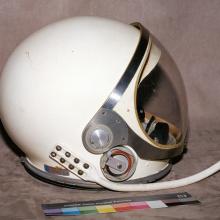 Helmet in profile with communication connection visible. 