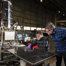 Museum conservator David Blanchfield and space history curator Matt Shindell examining the Ranger 7 spacecraft