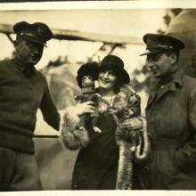 A woman holding two monkeys