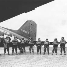 row of men men standing in front of an aircraft