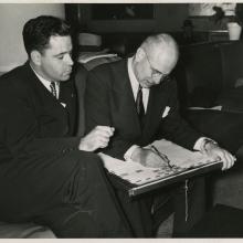 Jimmy Doolittle Signs the 1949 Around the World Envelope while Lanphier watches