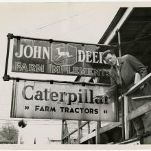 Man points to sign for caterpillar tractors