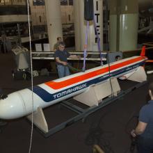 Staff encircle the missile as it is lowered to the ground