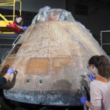 Conservators work on the Command Module Columbia