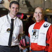 Man wearing Apollo 11 mission control costume and man wearing Star Wars costume