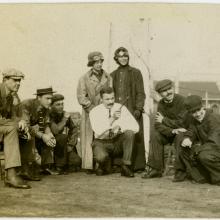 Five men and two women watch a man pointing