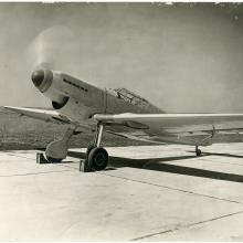 Messerschmitt on concrete with cholks on front wheels, nose facing the camera. 