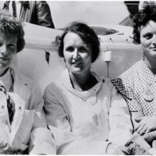 Earhart, Nichols, and Thaden sit shoulder to shoulder in this black and white photo.