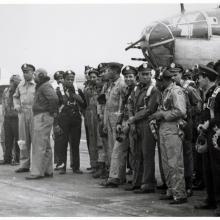 Group of African American airmen in front of aircraft