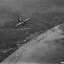 Flying medium bomber with invasion stripes