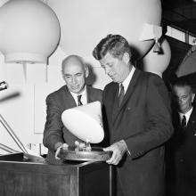 Man holding command module model with John Kennedy